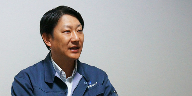 室内でインタビューに応じる早瀬崇之さんのポートレート