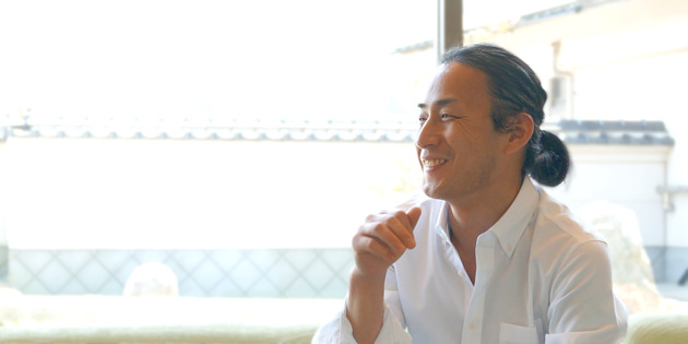 白いシャツを着て笑顔で話す料理人・写真家の沼本吉生さん