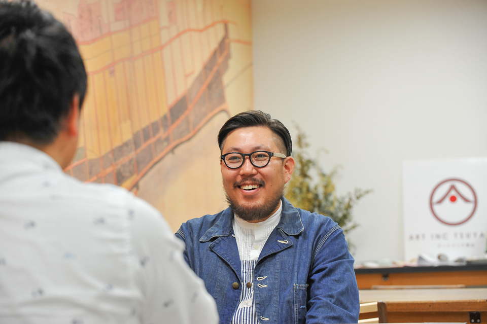 室内で身振り手振りを交えて笑顔で話す佐藤さん