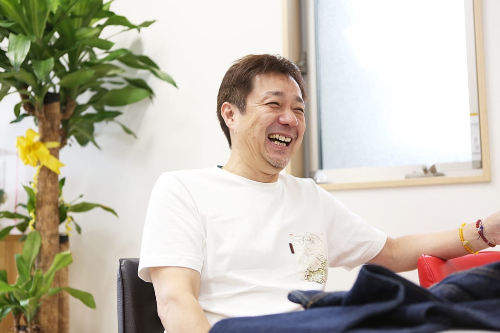 テーブル席で笑顔で話す内田政行さん