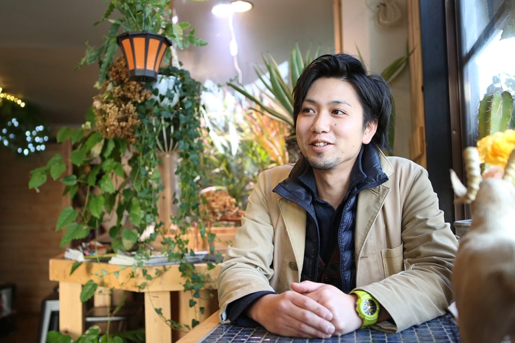 店内のテーブル席でインタビューに答える藤原康介さん
