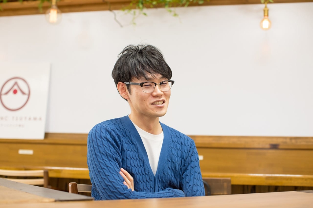 テーブル席で腕を組み話す山田邦明さん