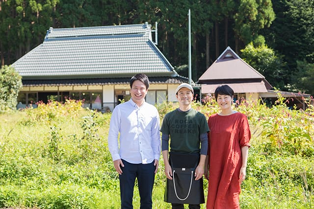 古民家風の店舗を背景に並ぶ男女3人