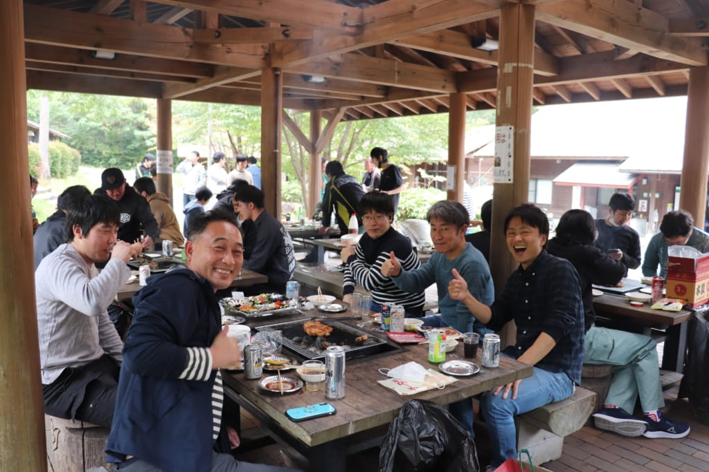 集まって屋外で食事をしているたくさんの社員たち