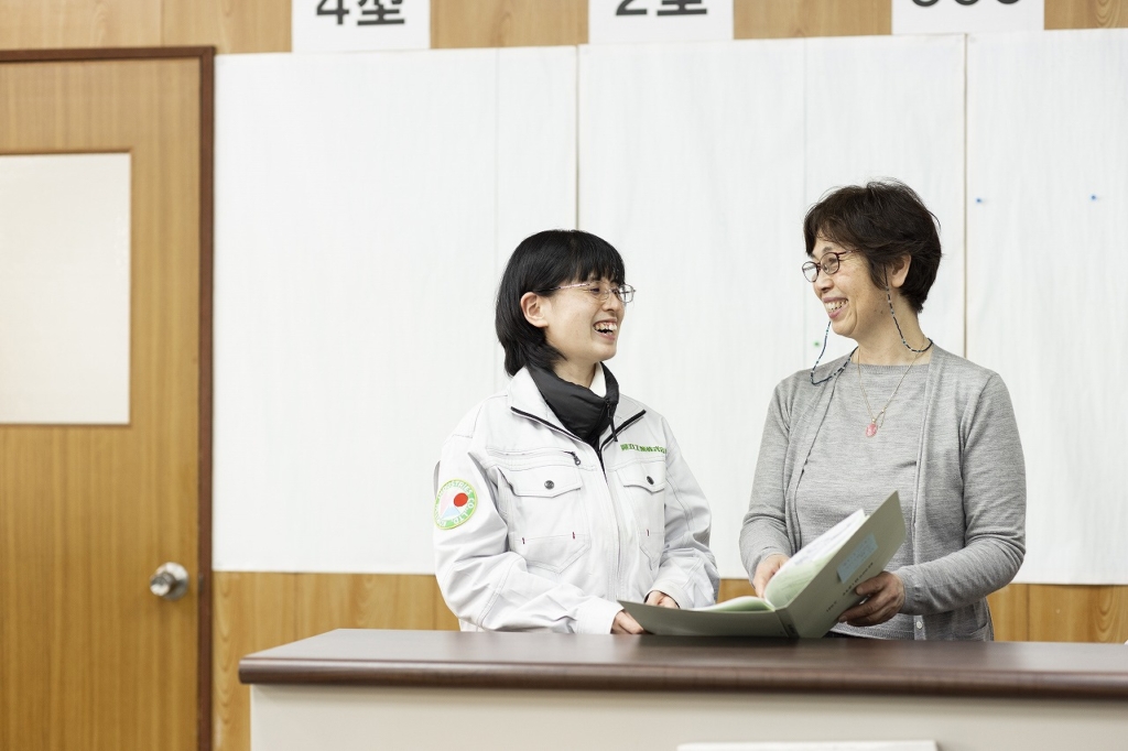 笑顔で意見交換する事務社員