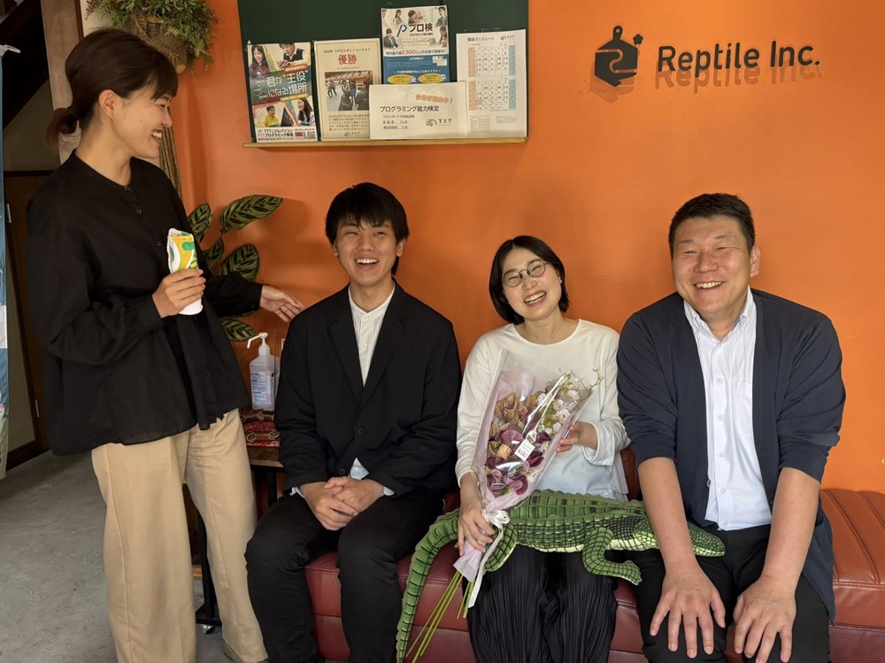 社内のソファに座っている4人の写真