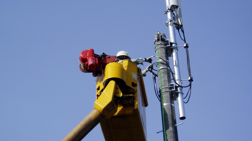 高所作業車に乗り電柱の工事をする作業員