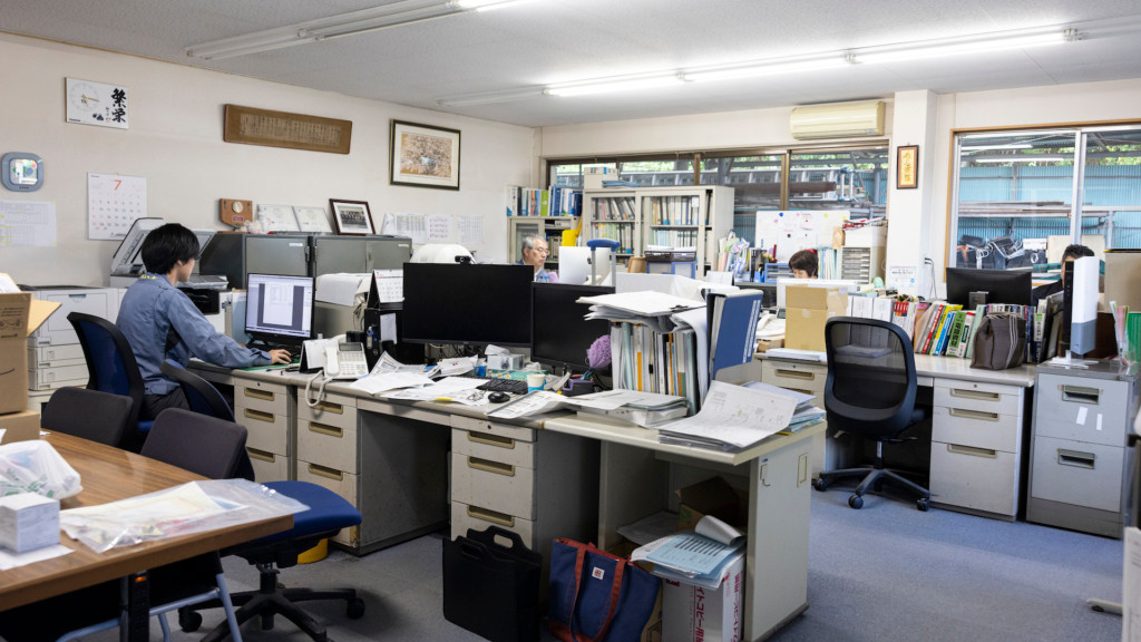 事務所内でデスクワークをする社員たち