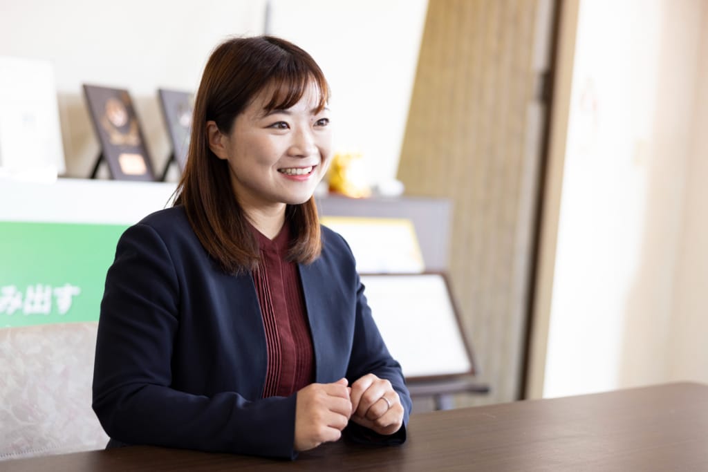 オフィスでのインタビュー中、笑顔で話す牛垣希彩さん。