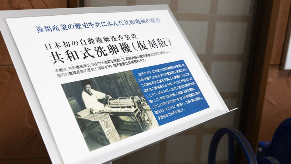 会社のエントランスに展示されている「共和式洗卵機（復刻版）」の説明看板