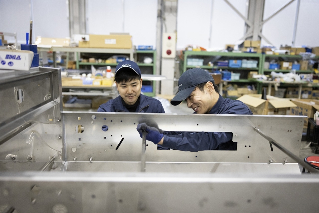機械の製造作業をする2名の社員