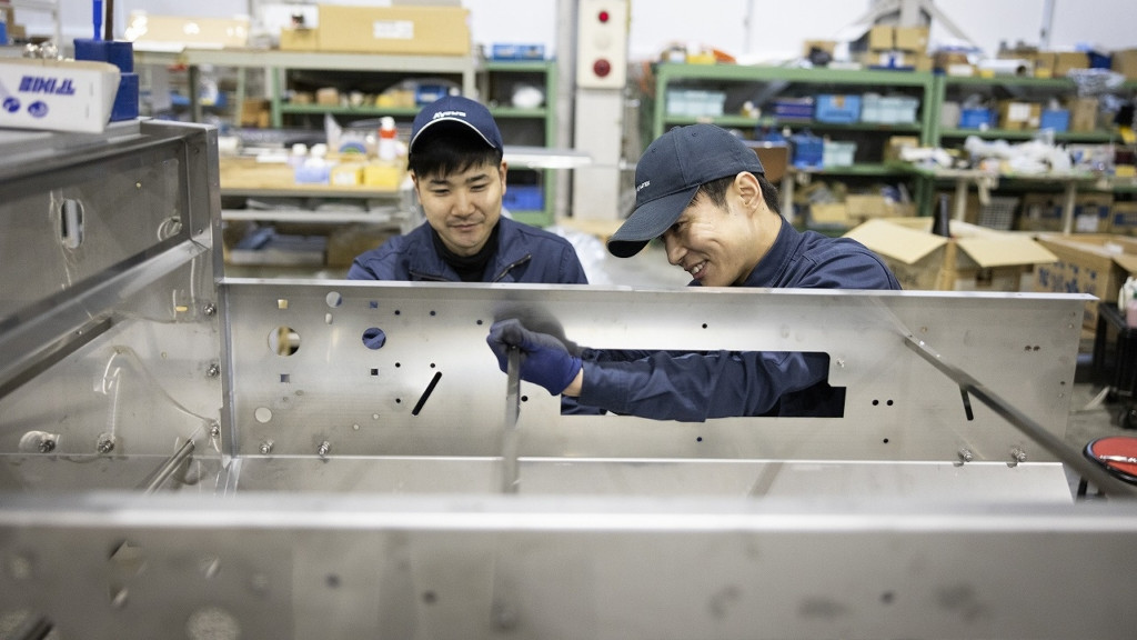 機械の製造作業をする2名の社員