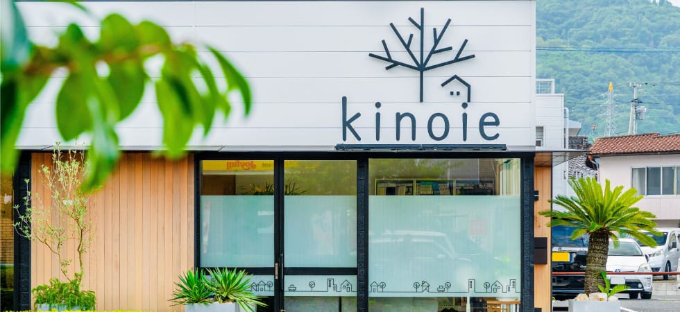 岡山県津山市にある株式会社キノイエのオフィスの外観。白い壁に黒い「kinoie」のロゴが見える。