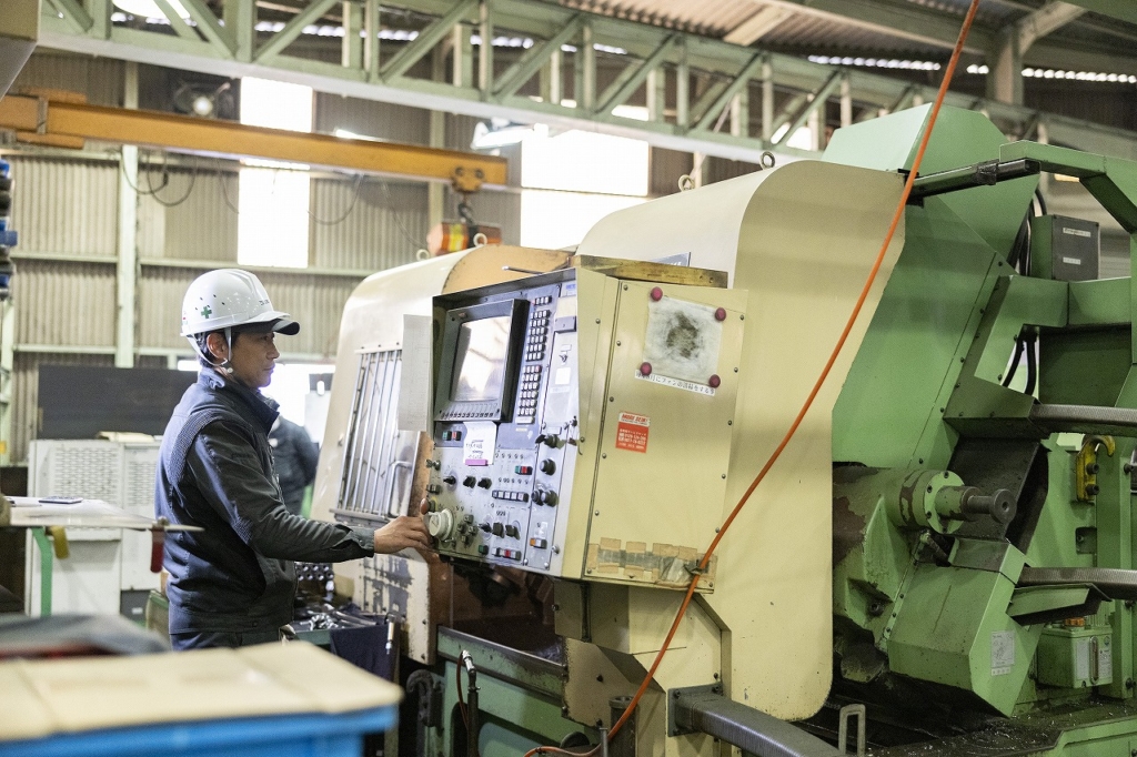 工場内で機械を操作する社員