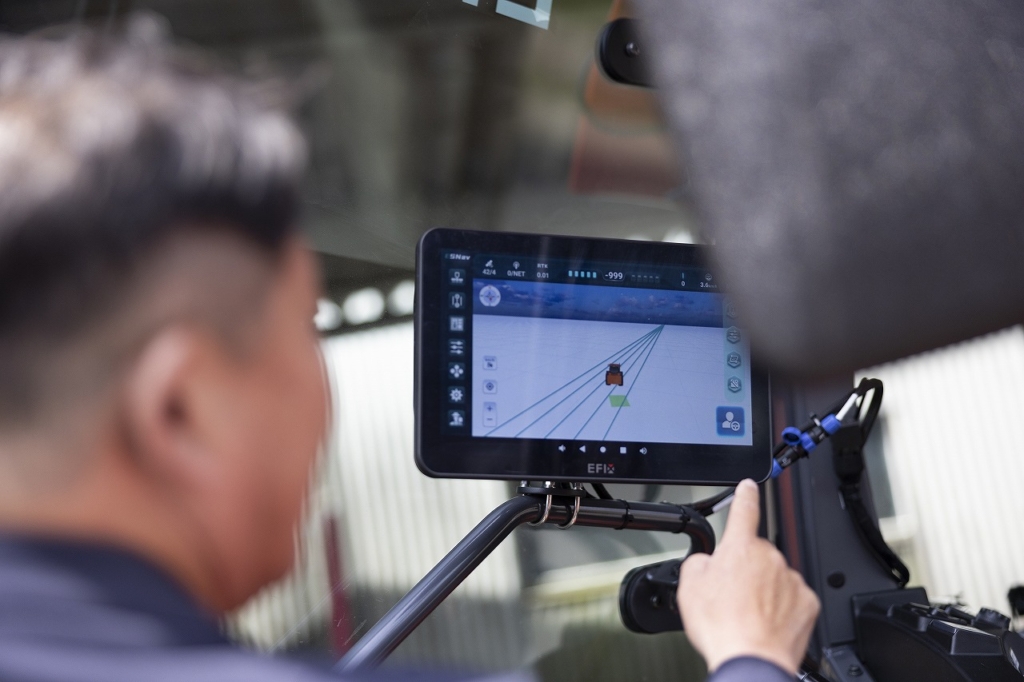 スマート農機のモニターをチェックする社員の様子
