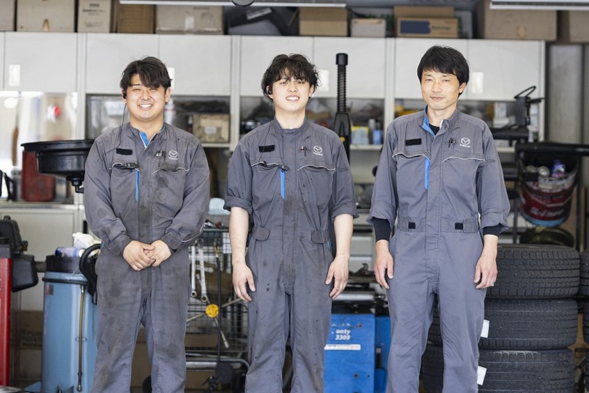 作業服で笑顔の写真を撮影する整備士の社員達