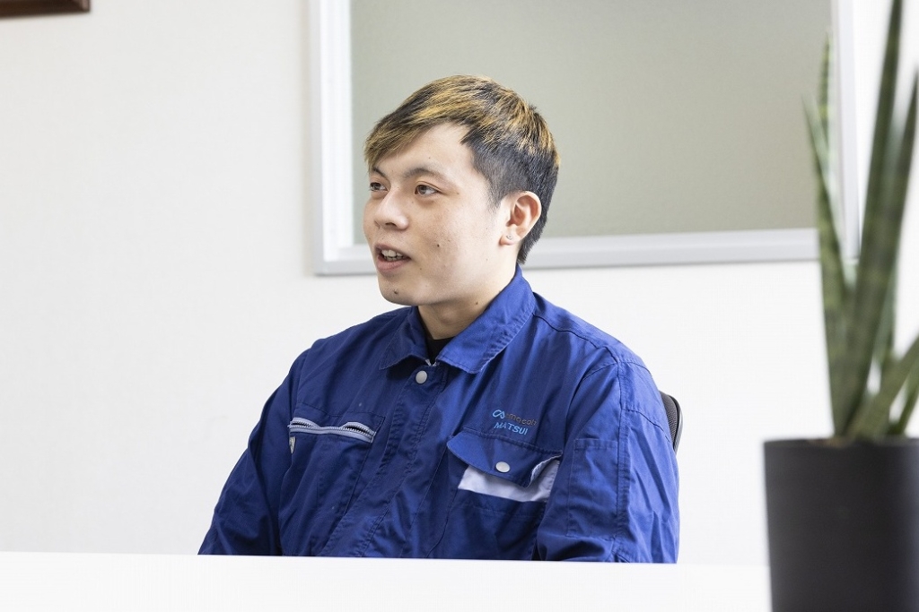 尼﨑工作所のオフィスでインタビューを受ける若手社員、入社後のキャリアや仕事のやりがいを語る