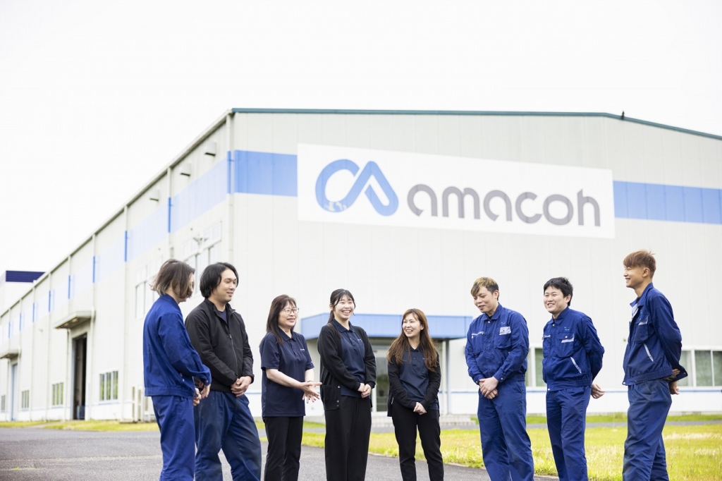 奈義町にある尼﨑工作所岡山工場の前で談笑するスタッフたち