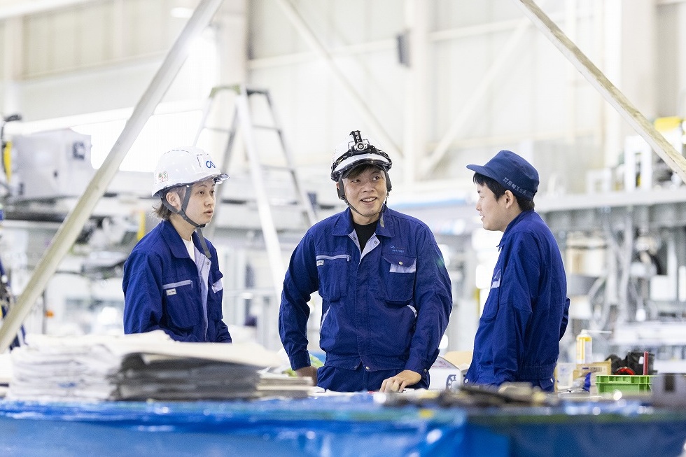 奈義町にある尼﨑工作所で組立の相談をする社員