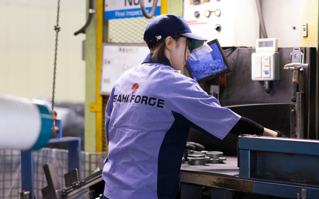 金属部品を前に作業をしている女性社員