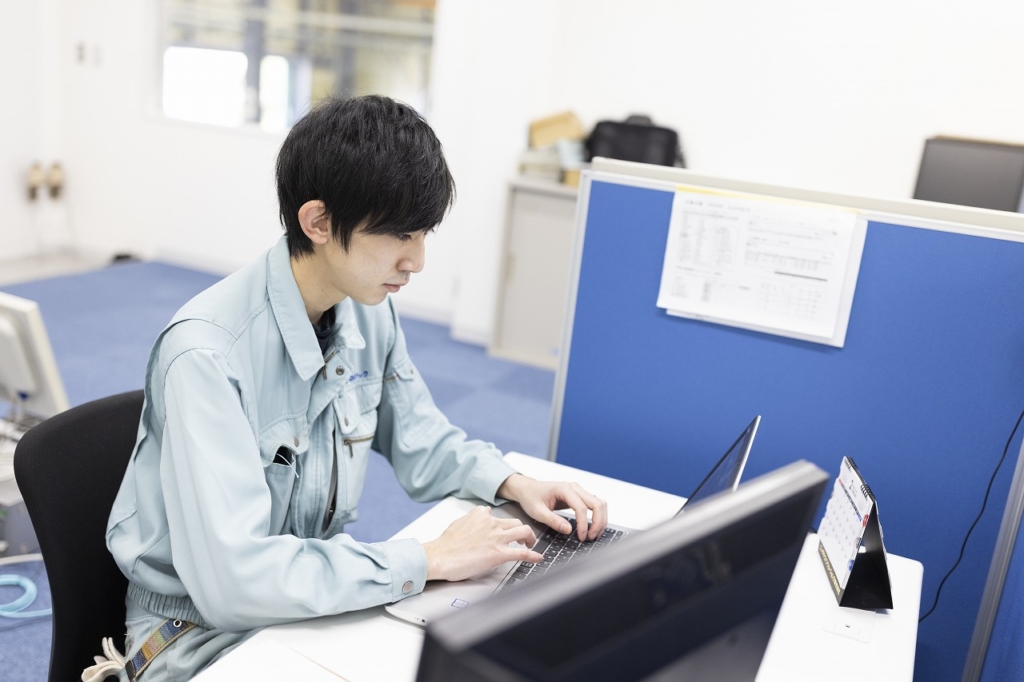 ラップトップに向かって作業をしている林さん