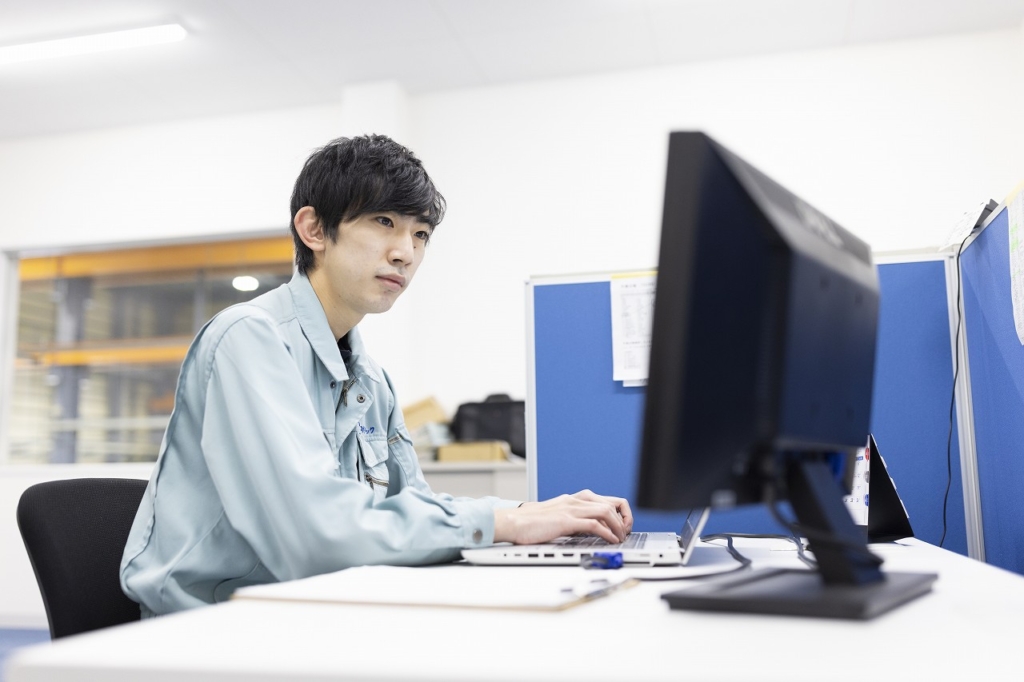 ラップトップに向かって作業をしている男性