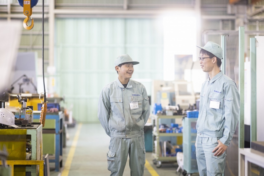 工場内で二人の社員が立って話している