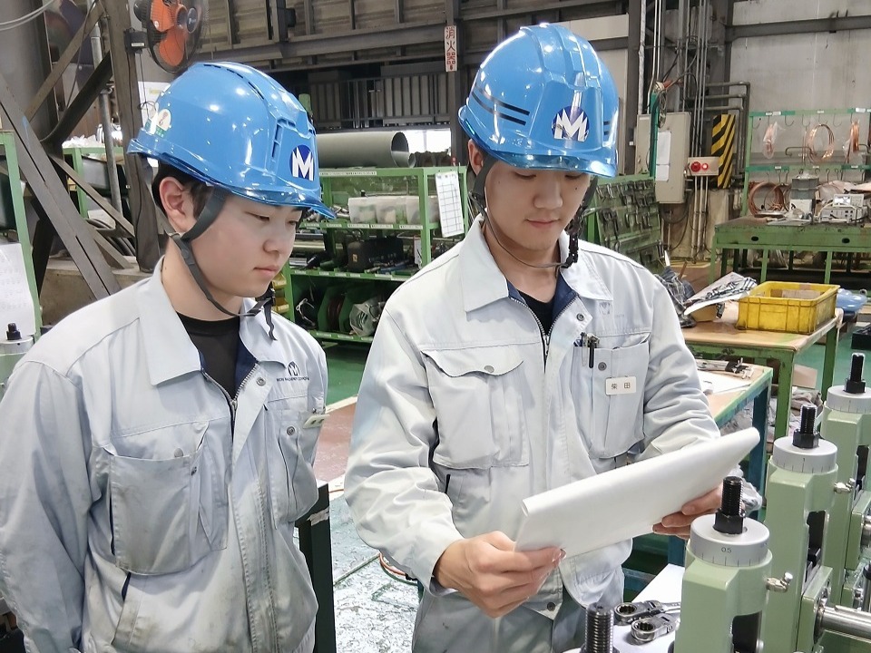 書類を見ながら作業について話し合う社員