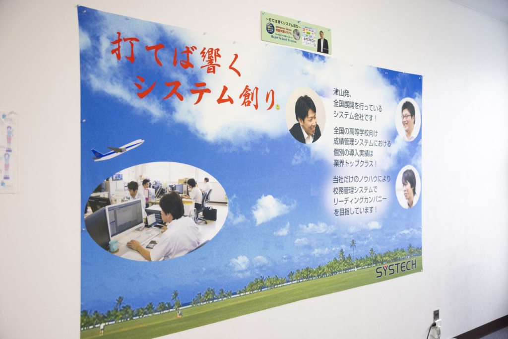 「打てば響くシステム創り」というスローガンが書かれた、青空と飛行機のデザインのポスター。
