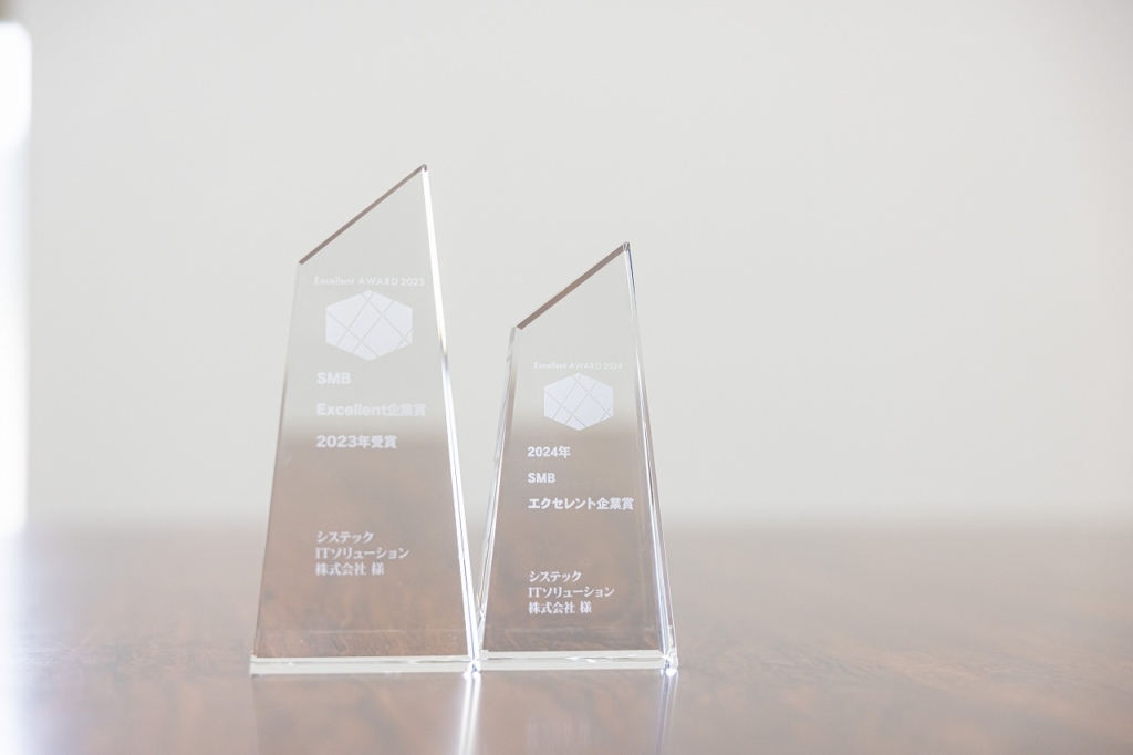 「Excellent AWARD 2023」と「Excellent AWARD 2024」の文字が刻まれた2つの透明なトロフィー