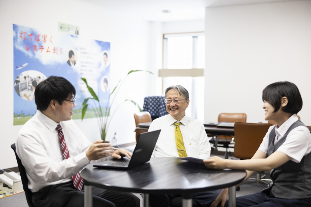 円卓を囲んで座り、楽しそうに話し合っている社長と従業員