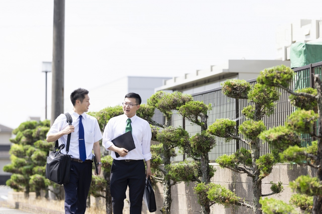 外で並んで歩きながら会話をしている2人の従業員