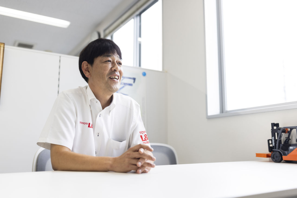 トヨタL&F岡山 津山営業所の北畠所長がオフィスでインタビューに答えている。