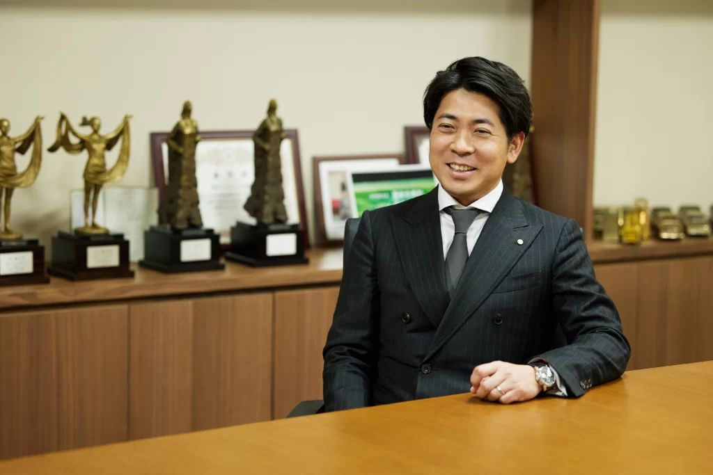 SUENAGAグループの代表である末長一範氏が、オフィスでコメントをしている。
