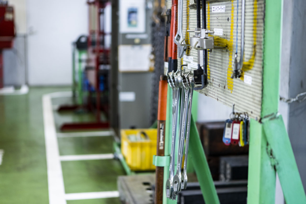 壁に整理整頓されて掛けられたスパナなどの工具類。