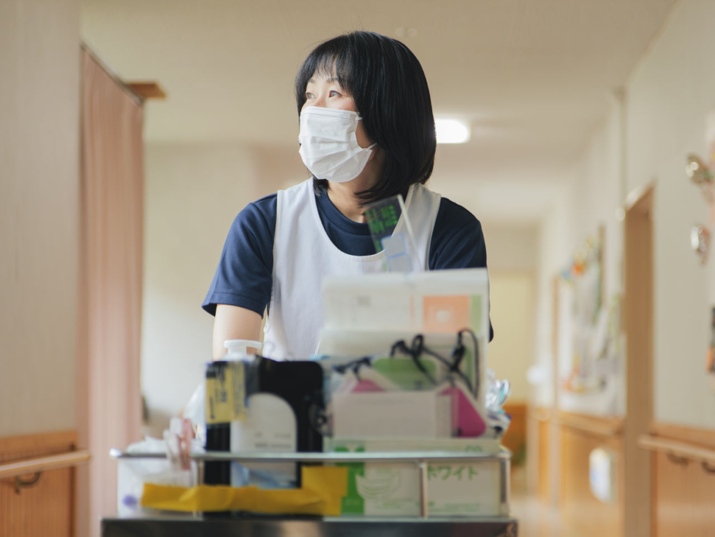 「白寿荘」の廊下でケアの準備をする看護師
