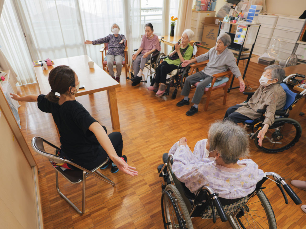 介護施設のレクリエーションで体操をする利用者と職員