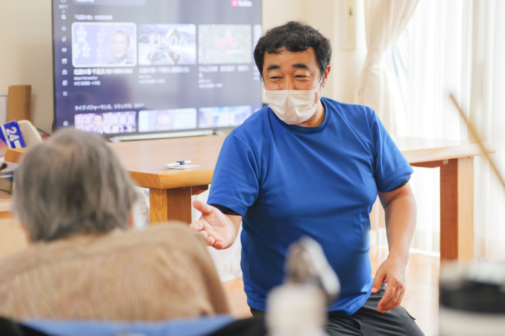 男性の介護職員が利用者とレクリエーションを行う様子