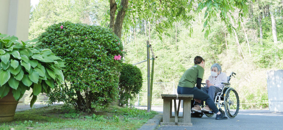 「白寿荘」の職員と車椅子の利用者