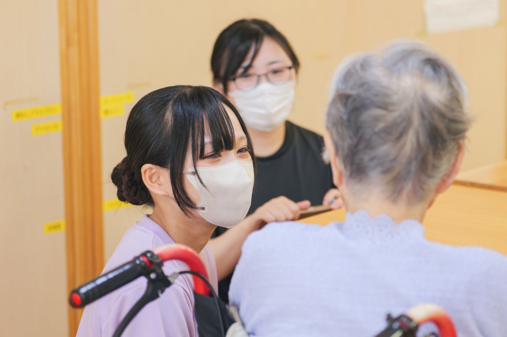 若い女性介護職員が利用者とコミュニケーションをとる様子