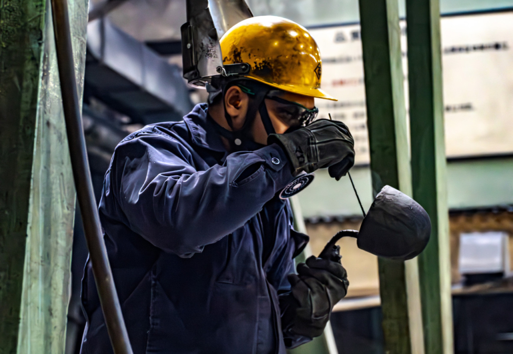 鋳造用取鍋の内部を作業員が点検・整備している様子