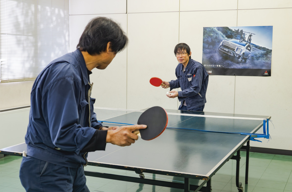 休憩スペースに設置された卓球台で卓球をしている二人の男性社員