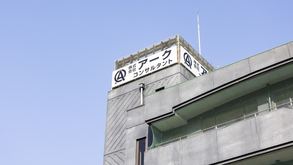 「株式会社アークコンサルタント」の看板が設置された社屋の屋上部分