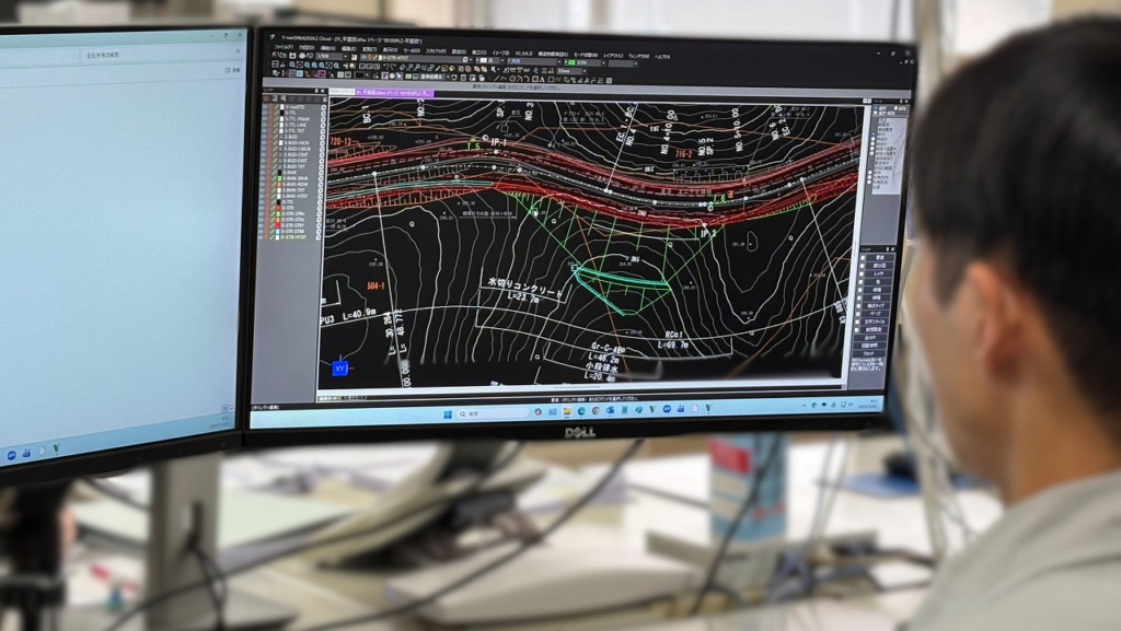 デュアルモニターを使用し、CADソフトで図面を作成している男性