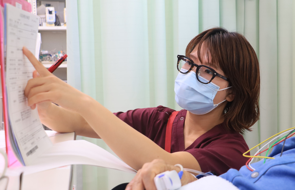 マスクを着用し、手元の書類を指差して確認している伊藤未宙さん