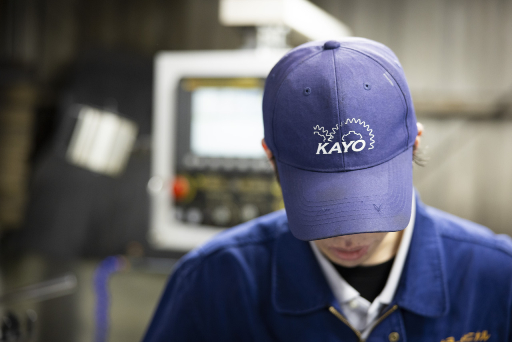 作業員が被っている会社のロゴ入り帽子のアップ