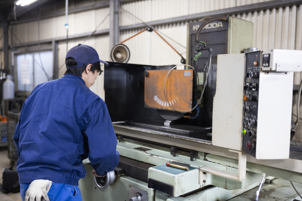 平面研削盤で金属を加工している様子