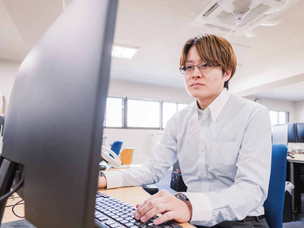 デスクトップパソコンを操作する社員