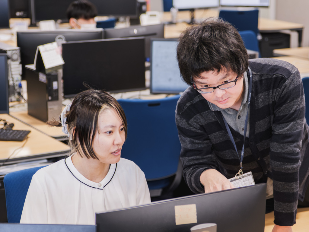 デスクでコミュニケーションを取っている2名の社員