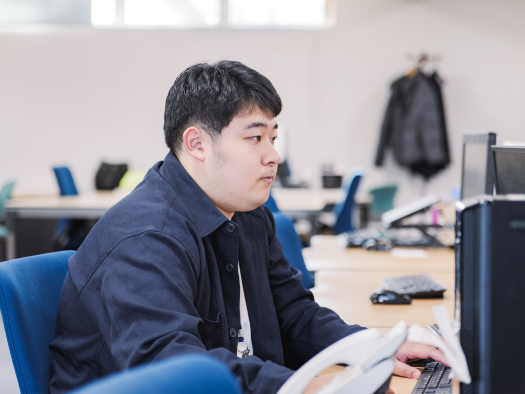 デスクでパソコン作業をする右手さん